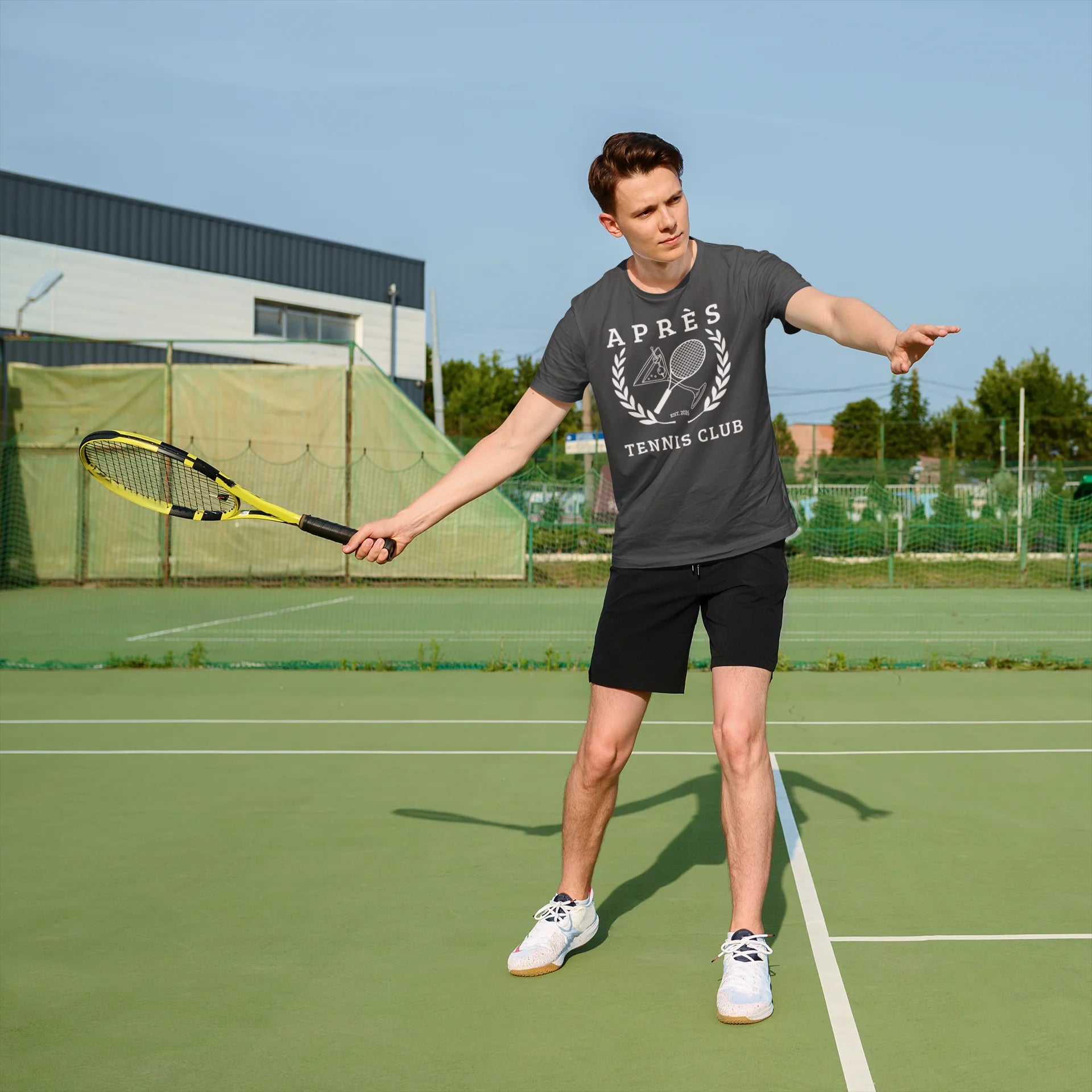 Tennis Club Shirt Man on a tennis court holding a racket, wearing an 'Après Tennis Club' t-shirt.