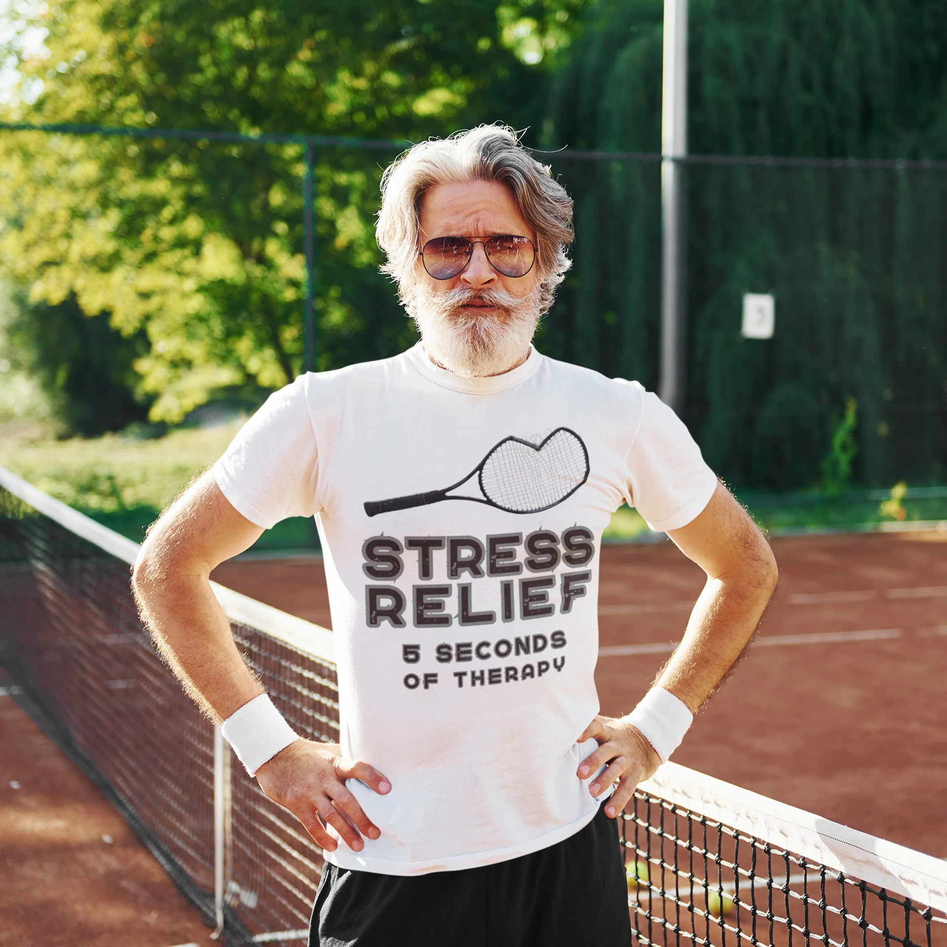 Man on a tennis court wearing a black t-shirt with 'STRESS RELIEF' text
