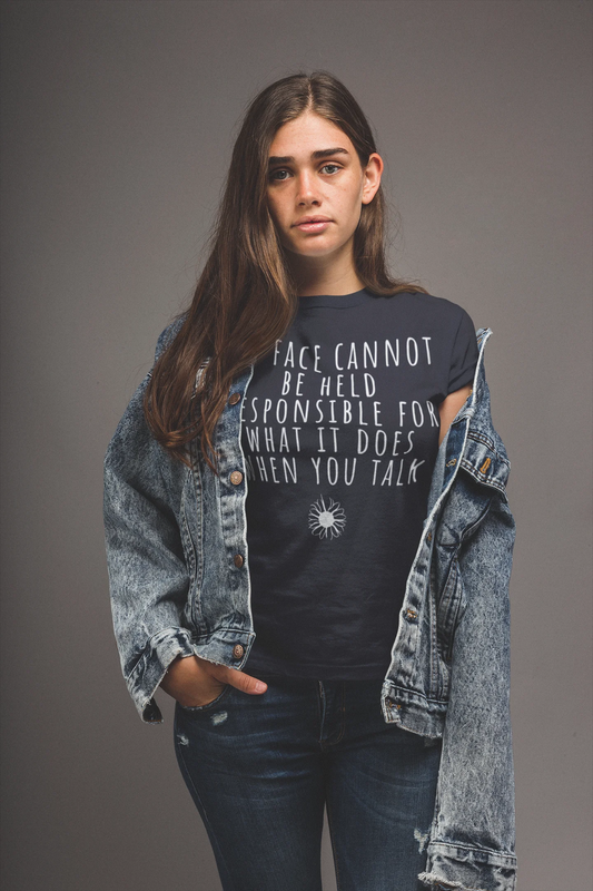 Person wearing a black t-shirt with text and a denim jacket on a gray background