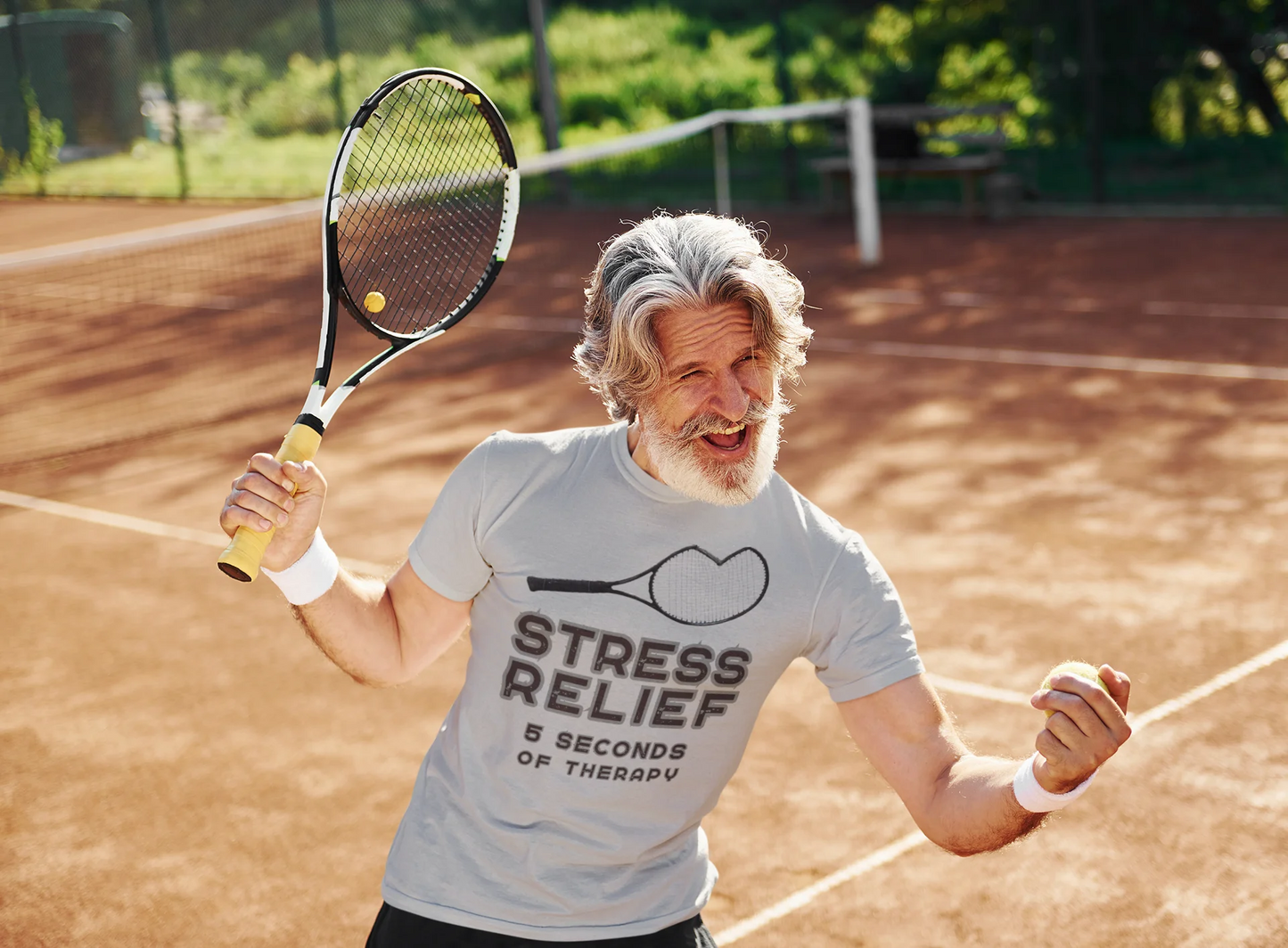 Man on a tennis court holding a racket with a 'Stress Relief' t-shirt.