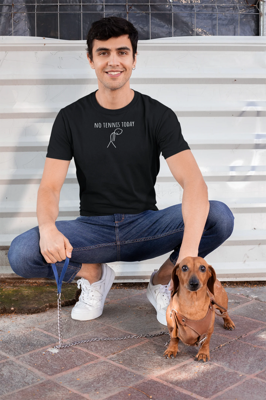 Man sitting on steps with a small dog, wearing a black t-shirt with text and graphics.