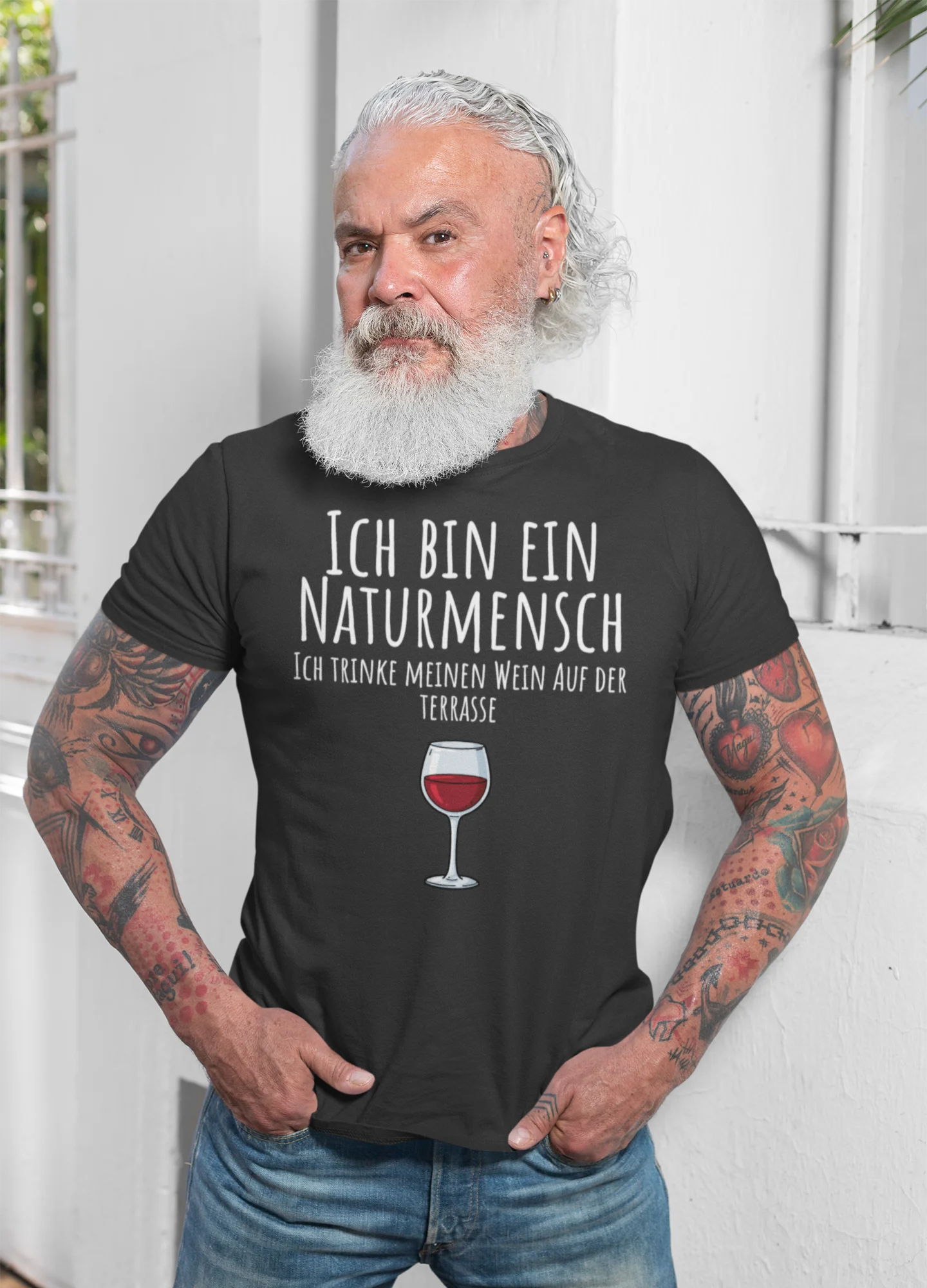 Man wearing a black t-shirt with German text and a wine glass graphic, standing against a white background.