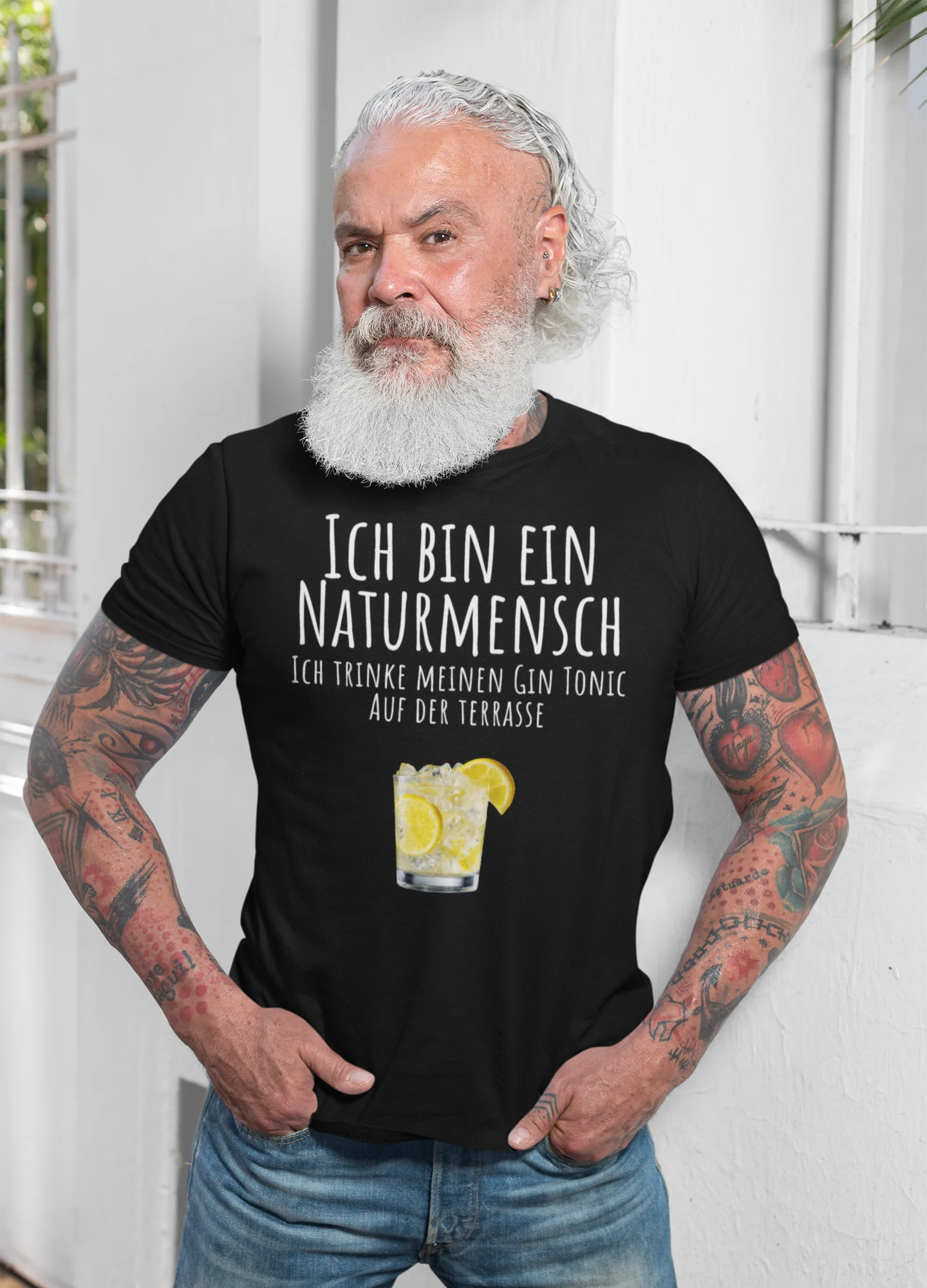 Man wearing a black t-shirt with German text and a lemon graphic, standing against a white background.