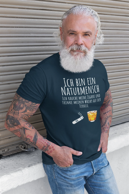 Man wearing a black t-shirt with German text and a graphic, standing in front of a metallic shutter.