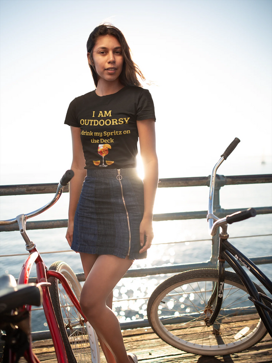 Funny Spritz Shirt Woman wearing a t-shirt with text and graphics, standing on a dock with bicycles.