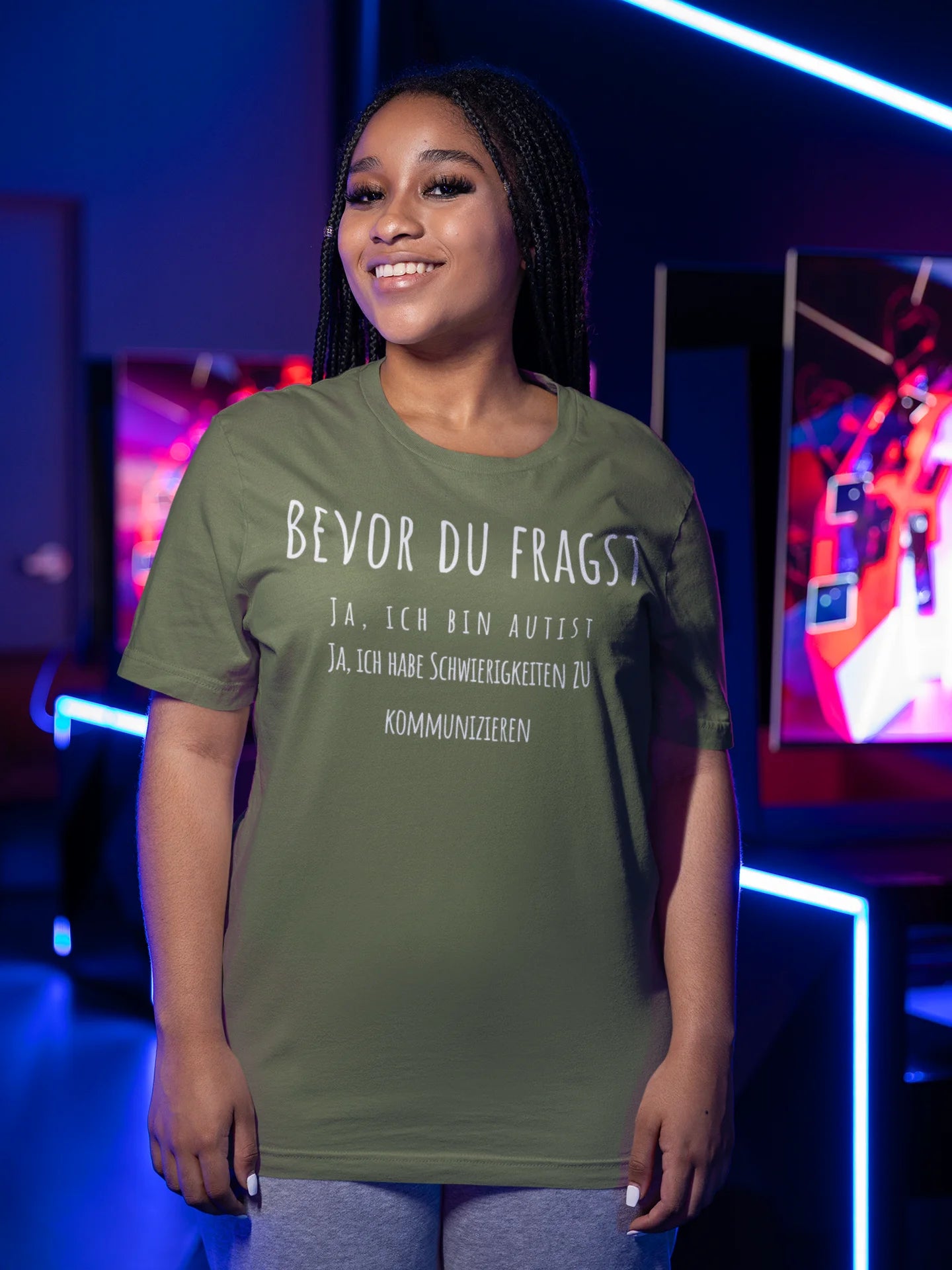 Person wearing a green t-shirt with text in a colorful indoor setting