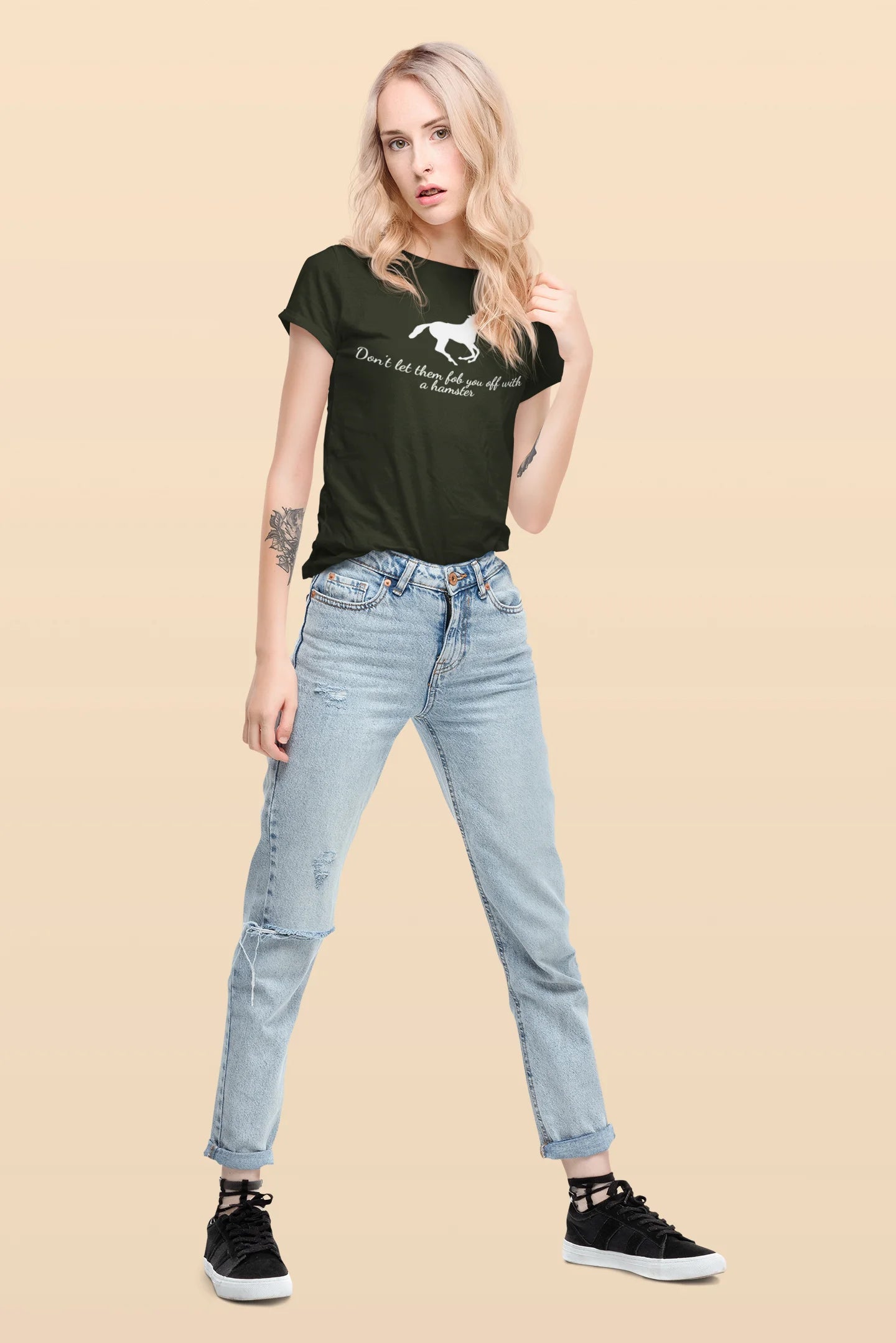 Equestrian Tee Woman wearing a black t-shirt with text and light blue jeans on a beige background