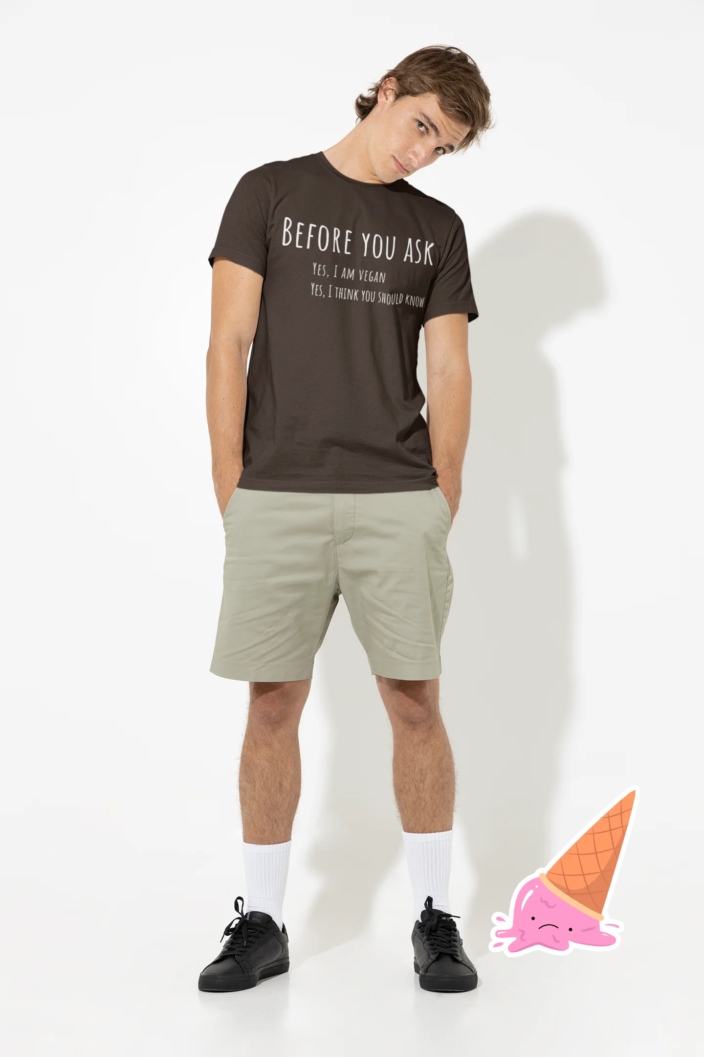 Man wearing a black t-shirt with text and beige shorts on a white background