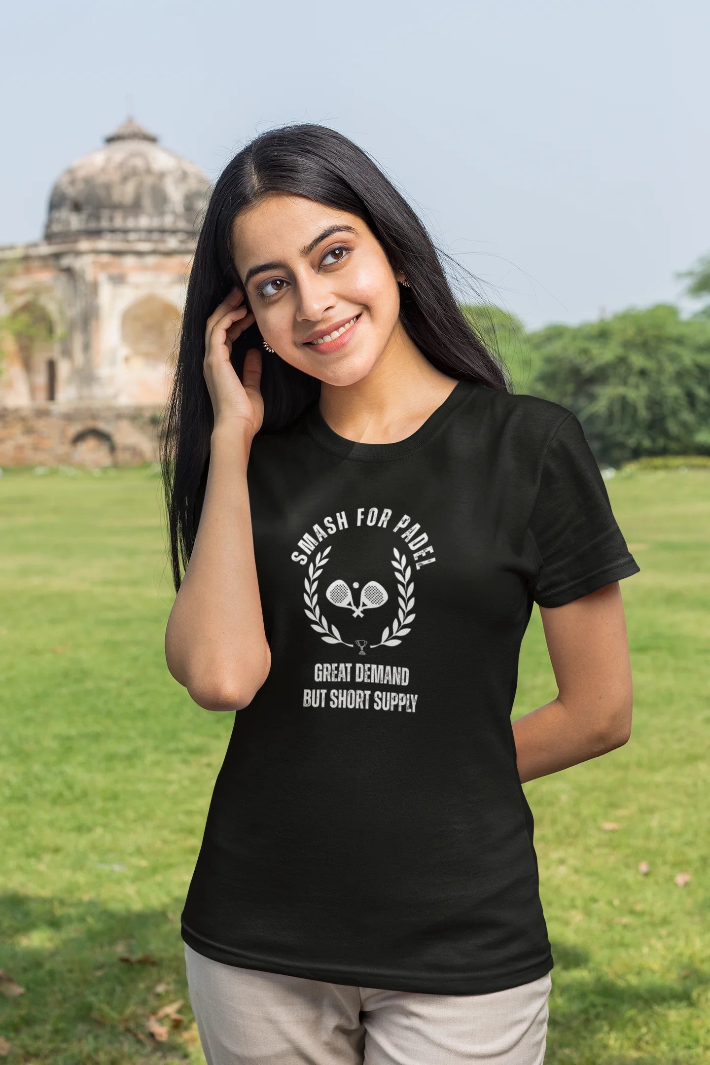 Woman wearing a black t-shirt with text and graphics in an outdoor setting