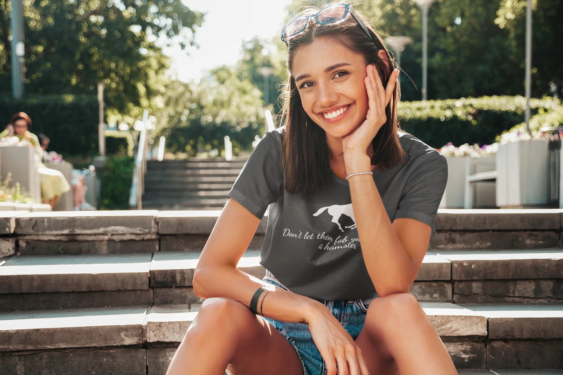 Equestrian Tee Woman sitting on steps outdoors wearing a t-shirt with text and graphics.