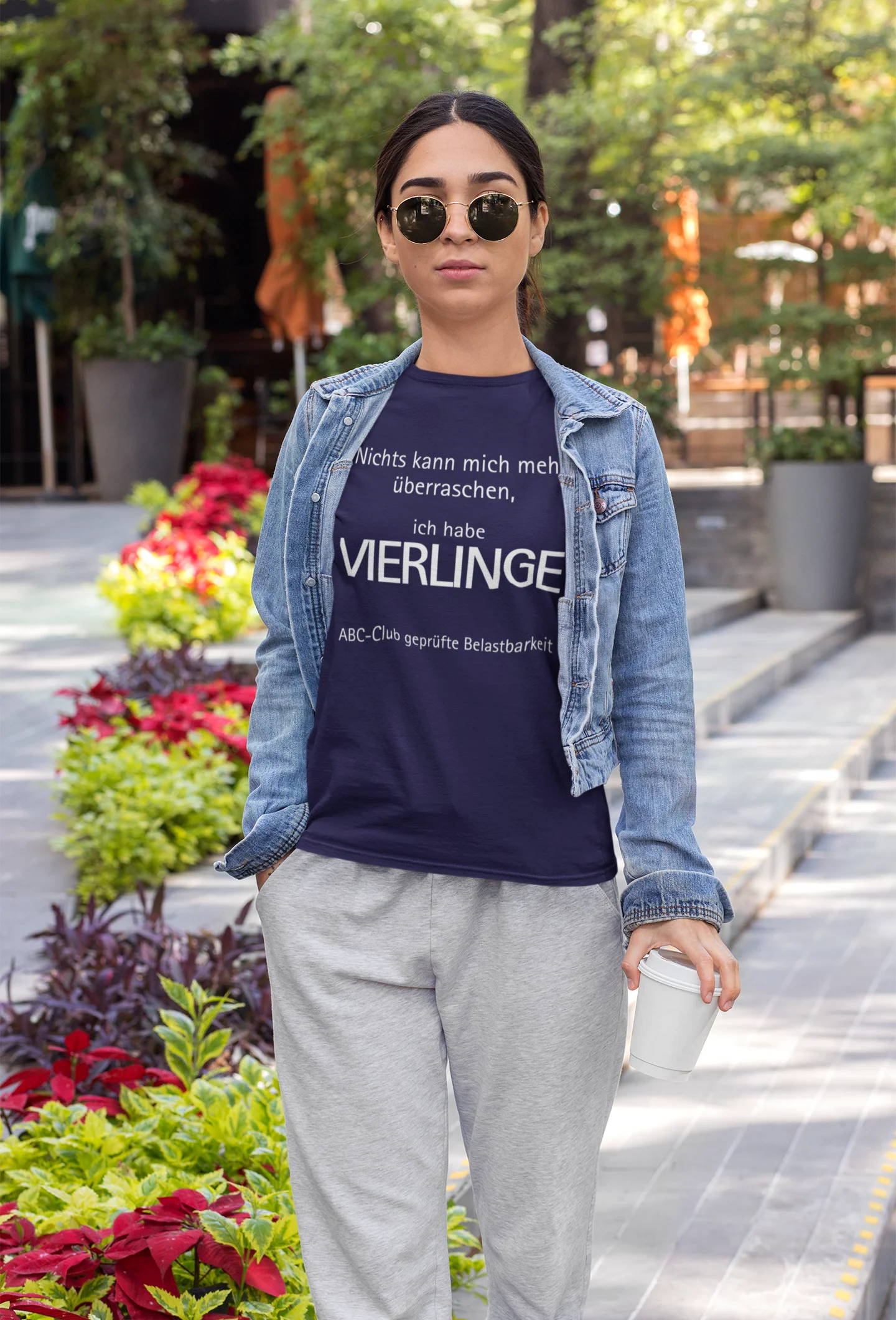 Vierlinge Eltern Shirt Person wearing a denim jacket and gray pants with a blue t-shirt in an outdoor setting.