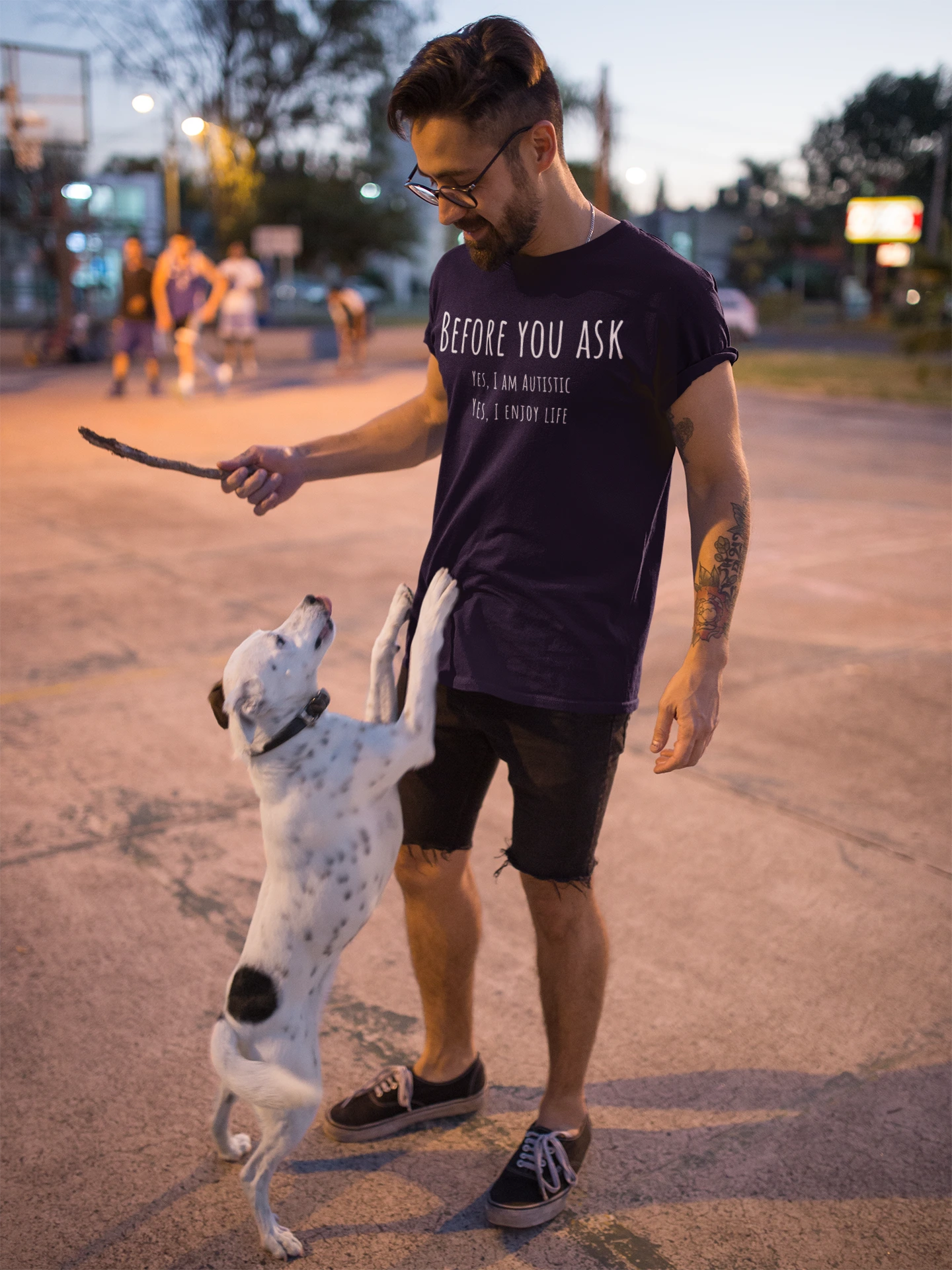 Man playing with a dog on an outdoor court at dusk