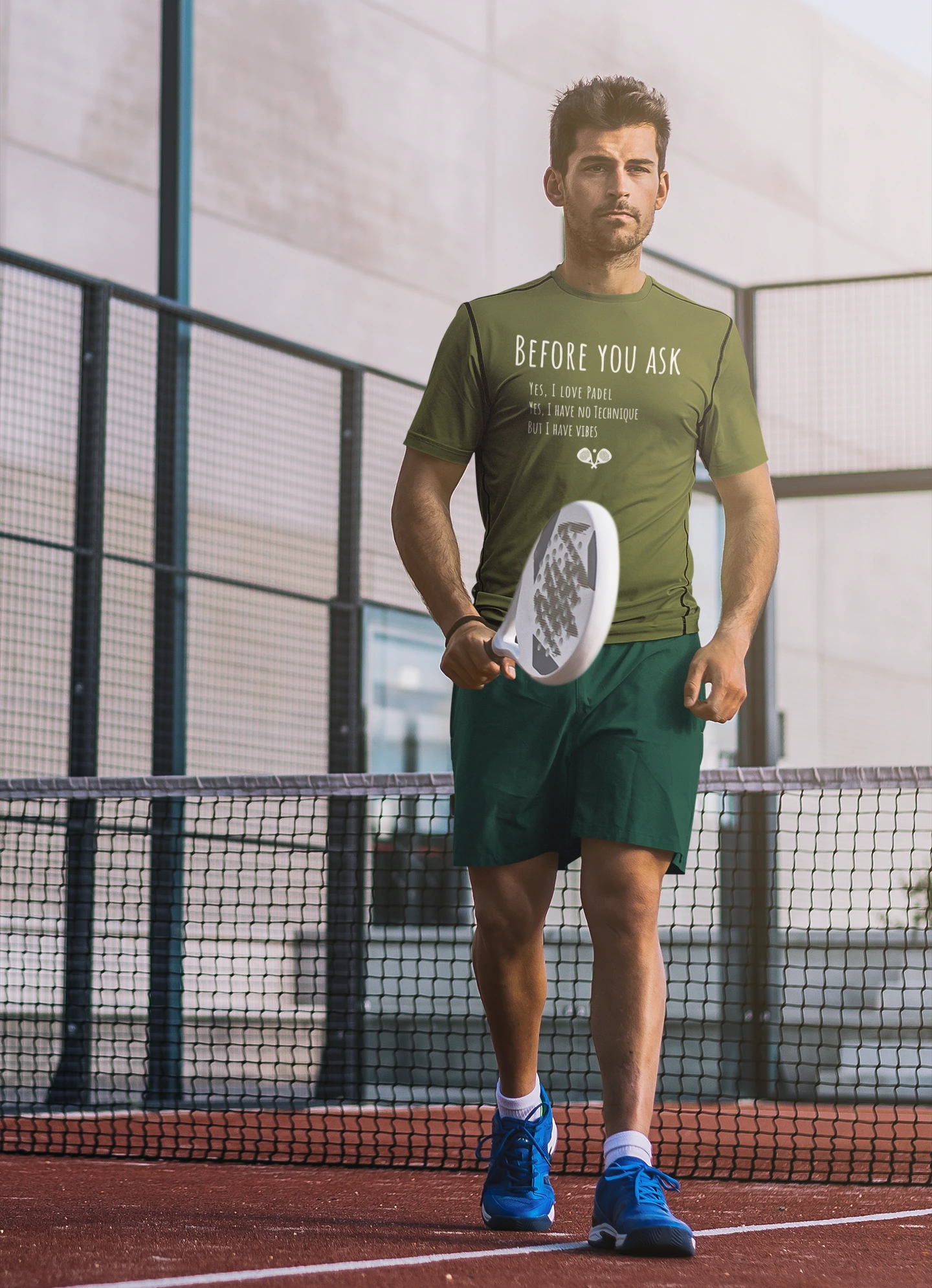 Man in green athletic wear holding a paddle on a tennis court