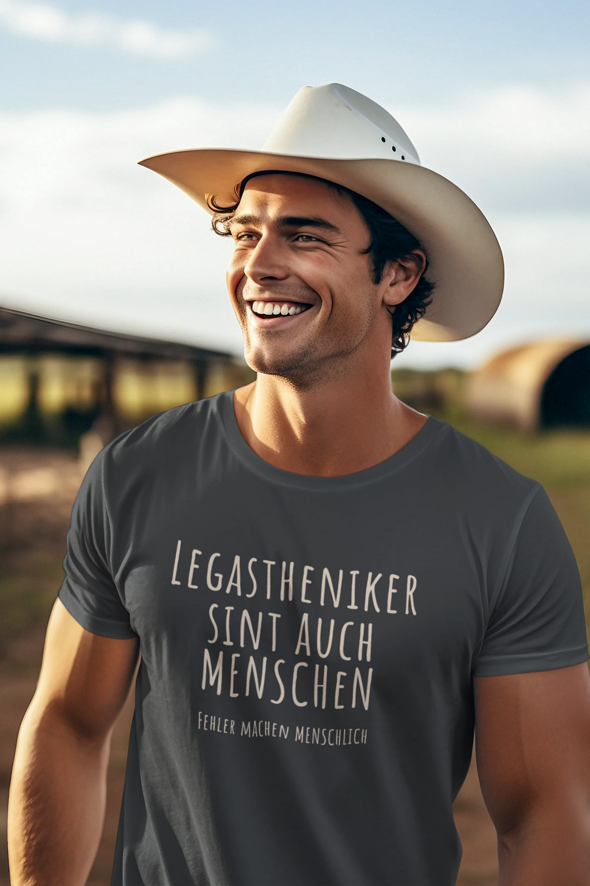 Man wearing a cowboy hat and a t-shirt with text in a rural setting
