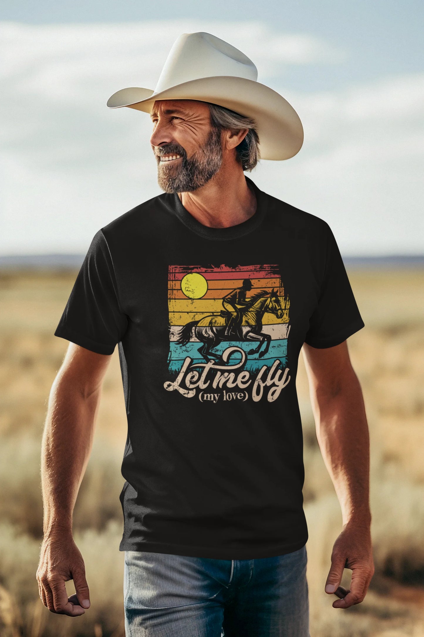 Man wearing a black t-shirt with a graphic design and text, standing in a desert landscape.