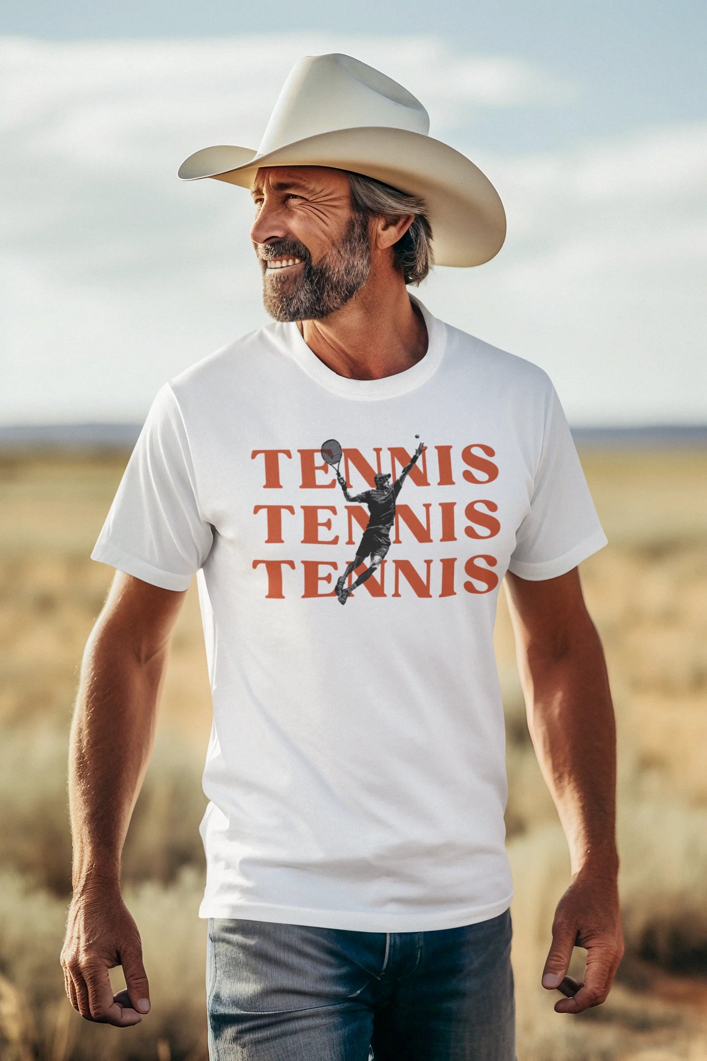 Man wearing a white t-shirt with 'TENNIS TENNIS TENNIS' and a graphic of a tennis player, standing in a desert landscape.
