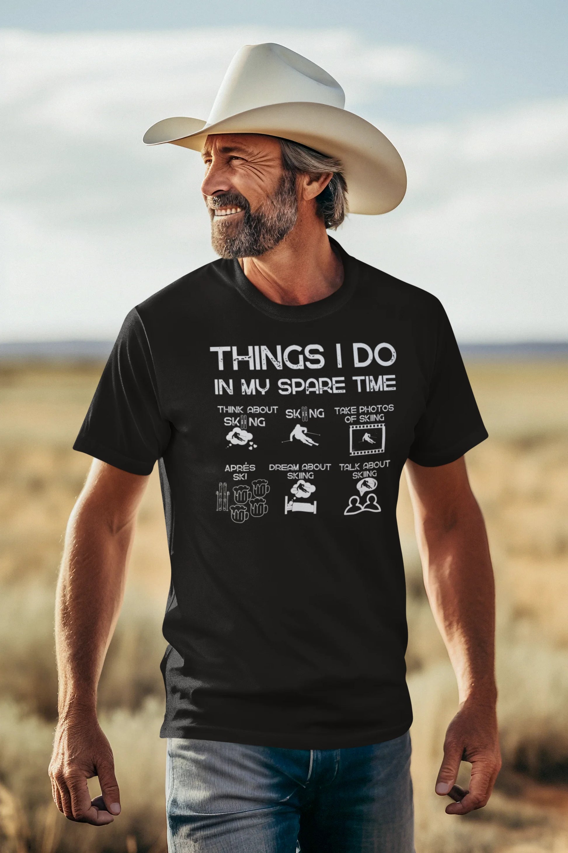 Man wearing a black t-shirt with text and graphics, standing in a desert landscape.