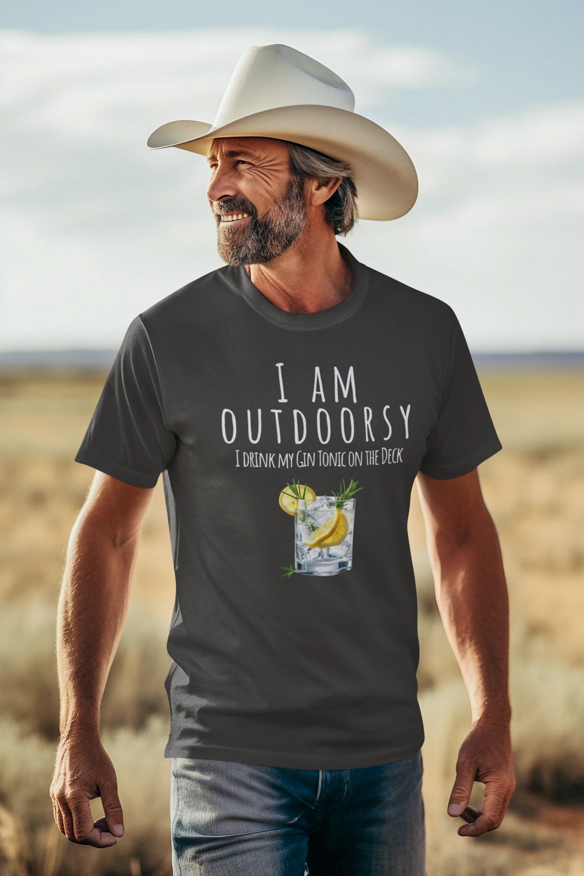 Man wearing a cowboy hat and 'I AM OUTDOORSY' t-shirt with a drink graphic in a desert setting