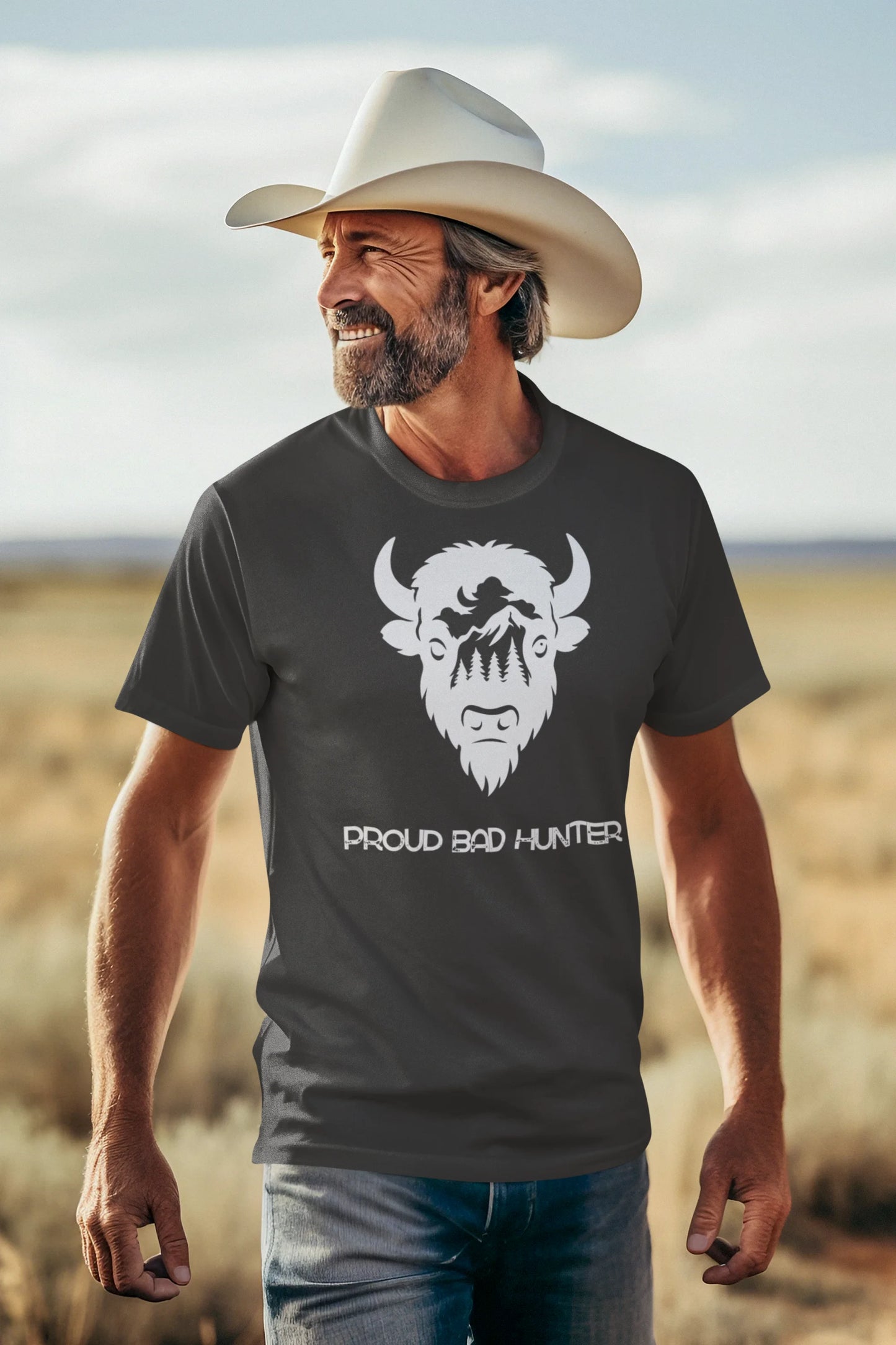 Man wearing a t-shirt with a graphic design and text, standing in a desert landscape.