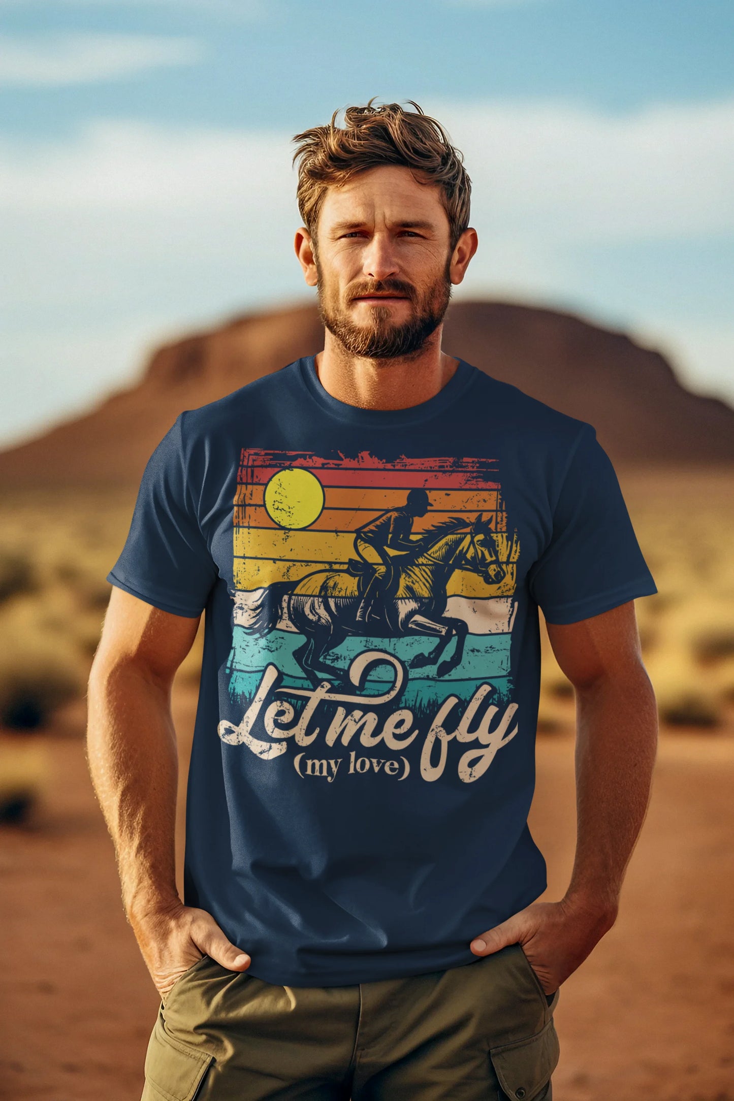 Man wearing a blue t-shirt with a graphic design and text, standing in a desert landscape.
