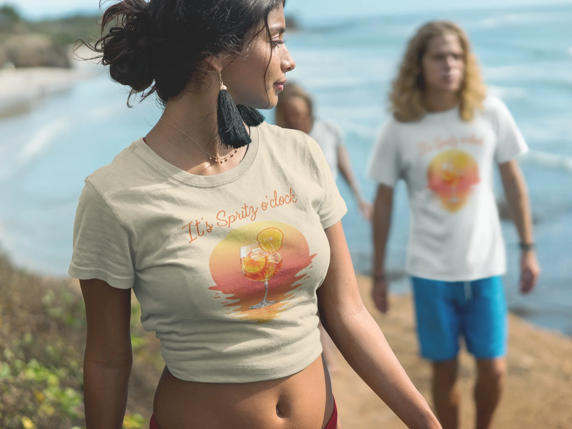 Aperol T-Shirt Woman wearing a t-shirt with a graphic design by the beach